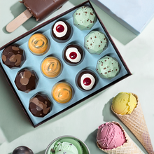 Load image into Gallery viewer, Open box of Ice Cream Truck Collection bonbons in mint, orange, and dark chocolate beside ice cream cones and a fudge pop.