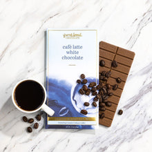 Load image into Gallery viewer, Cafe Latte White Chocolate bar wrapper and unwrapped bar with scattered coffee beans and a cup of coffee on marble.
